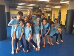 kids holding Kali Sticks in a martial arts gym