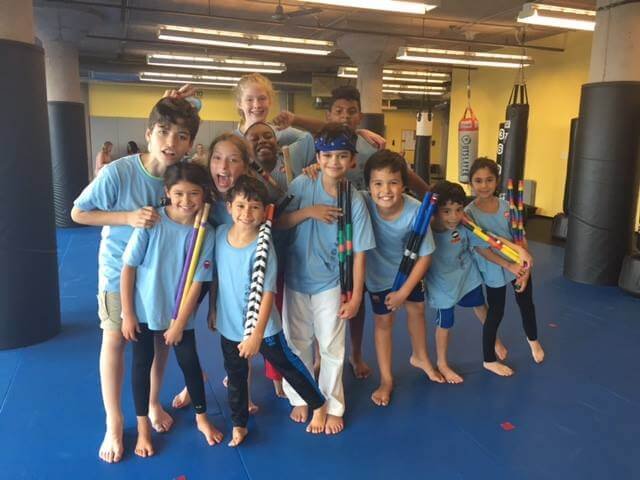 kids holding Kali Sticks in a martial arts gym