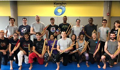 martial arts students holding kali sticks