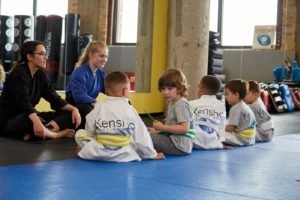 Young children sitting patiently before karate class begins